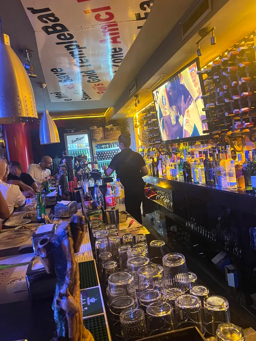 Comptoir du bar OTRIK à Tanger avec barman et sélection de bouteilles